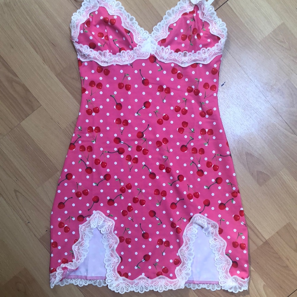 Pink bodycon dress with cherry pattern.
